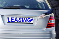 silver car with LEASING painted in blue